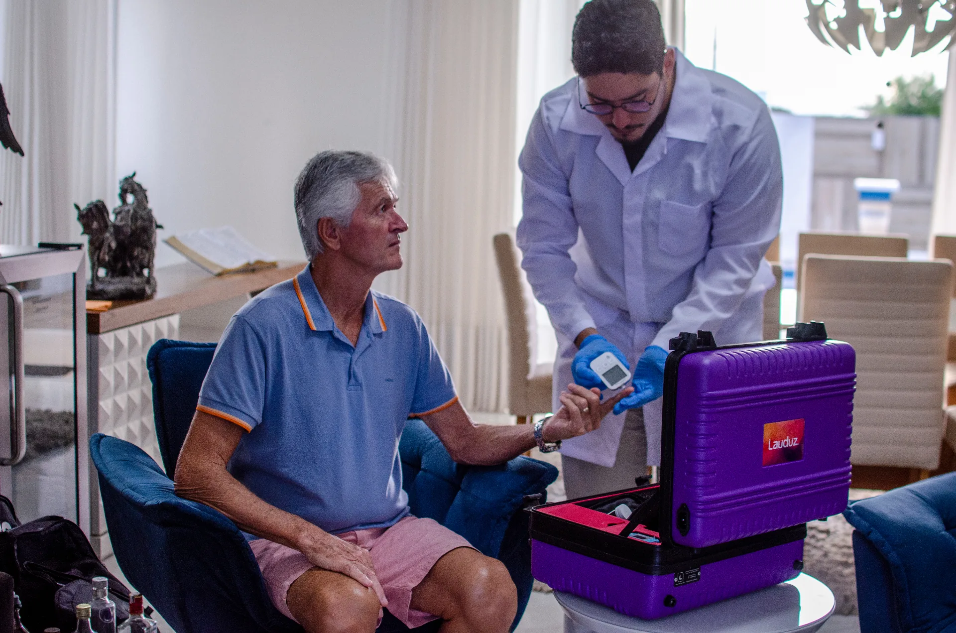 Enfermeira em atendimento domiciliar a idoso com o Telekit®, no case MedSênior x Lauduz