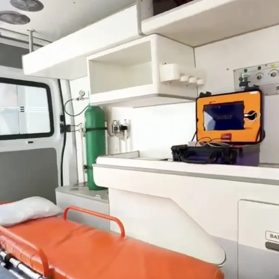Interior da ambulância da telemedicina de Sant'Ana do Livramento (RS) com a maleta Telekit® armada na bancada, ao lado da maca — consultório móvel da Lauduz.